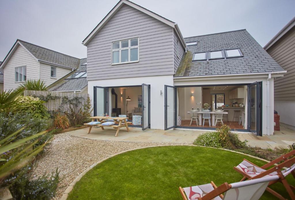 a house with a patio with a table and chairs at 5 The Sands in Polzeath