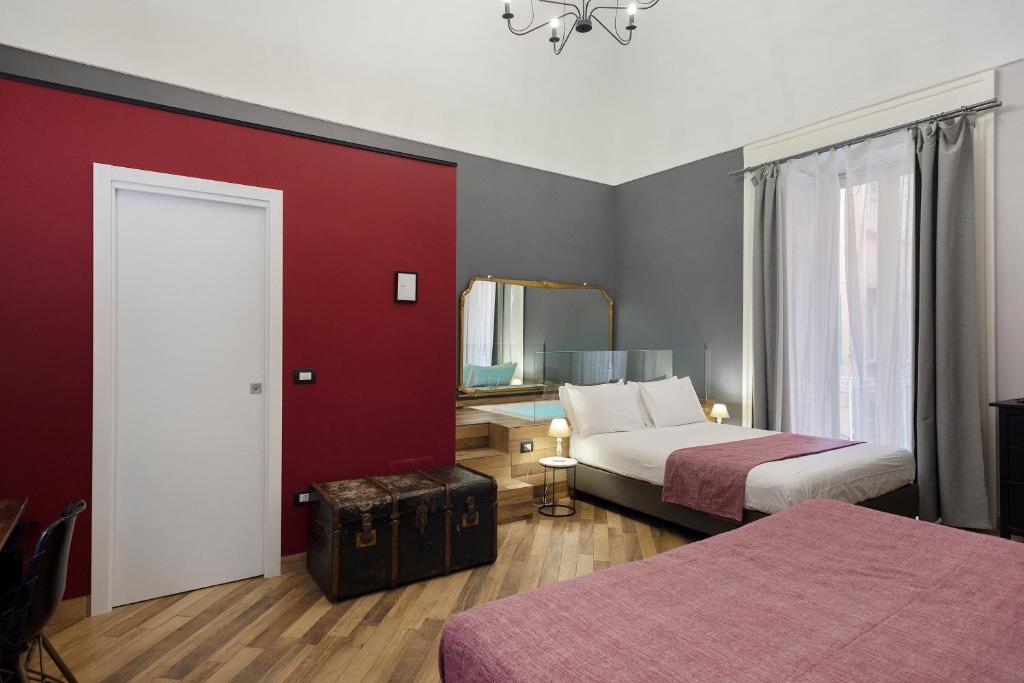 a hotel room with two beds and a mirror at Tredici Boutique Rooms in Naples