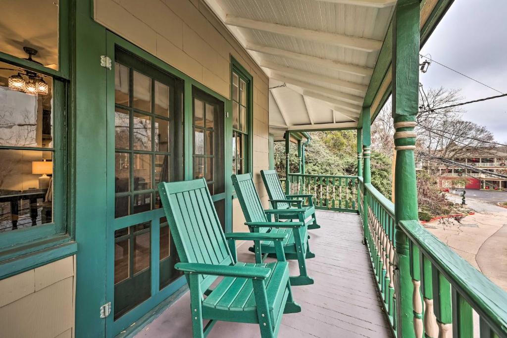 a row of green chairs sitting on a porch at Cozy Eureka Springs Cottage, Walk to Dtwn! in Eureka Springs