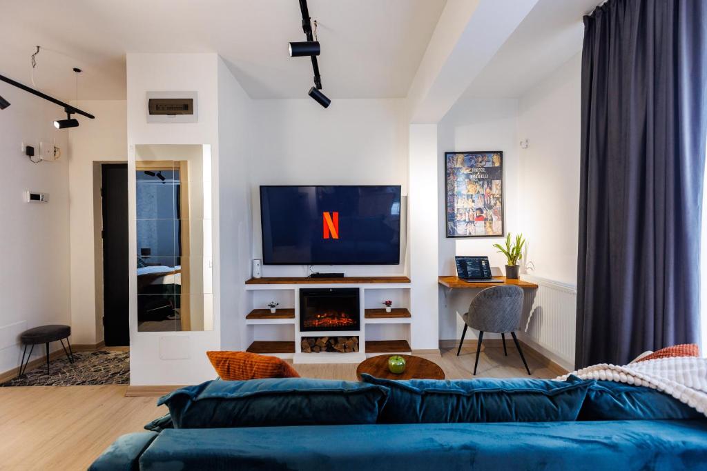 a living room with a blue couch and a tv at Touchdown Apartment near Bucharest Airport in Otopeni