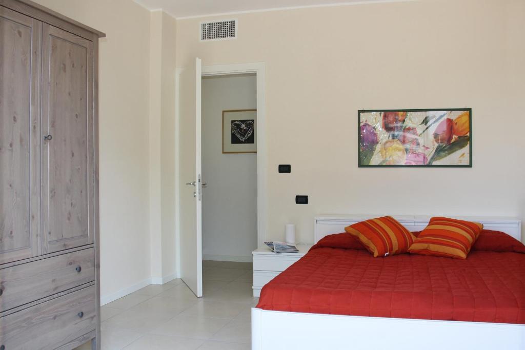 um quarto com uma cama com um cobertor vermelho em Grillo Casa Vacanze em Tessera