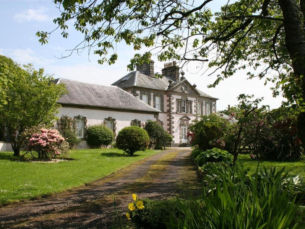 a large white house with a driveway at The Coach House at Stewart Hall in Rothesay