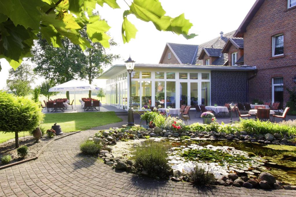 ein Haus mit einer Terrasse und einem Garten in der Unterkunft Landhotel Bartmann in Sendenhorst
