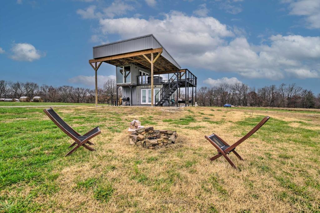 a couple of benches in a field with a building at One-of-a-Kind Container Home on Century Farm! in Mount Vernon