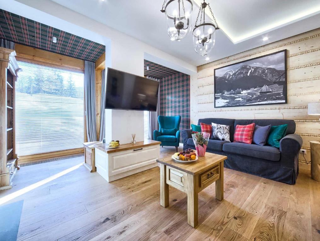 - un salon avec un canapé et une télévision dans l'établissement VisitZakopane - Coral Spa Apartment, à Zakopane
