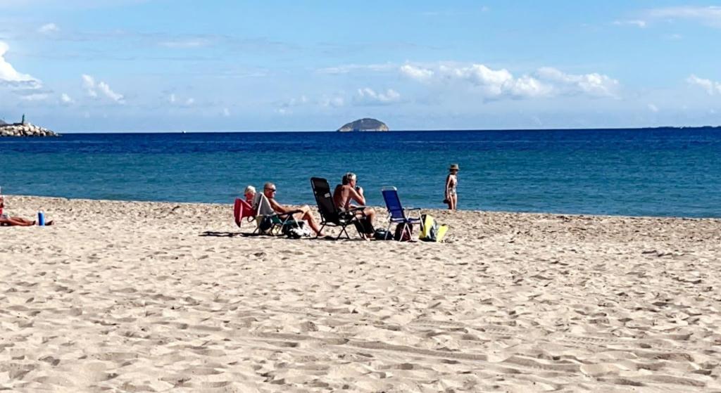 un grupo de personas sentadas en sillas en una playa en de Pz de la Iglesia 5, 3º Villajoyso en Villajoyosa