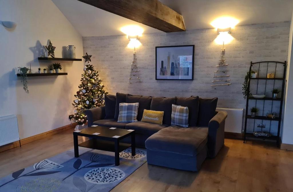 a living room with a couch and a christmas tree at The Studio in Farmborough