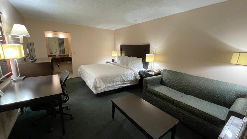 a hotel room with a bed and a couch at Slumber Inn Harrisonville in Harrisonville