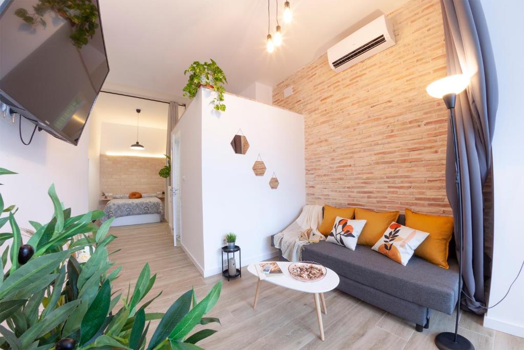 a living room with a couch and a brick wall at C - NOGUERA APARTMENTS - ARTS AND SCIENCIES in Valencia