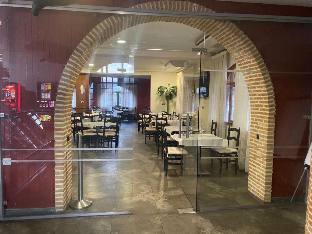 un arco en un restaurante con mesas y sillas en Hostal El Botero, en Monreal del Campo