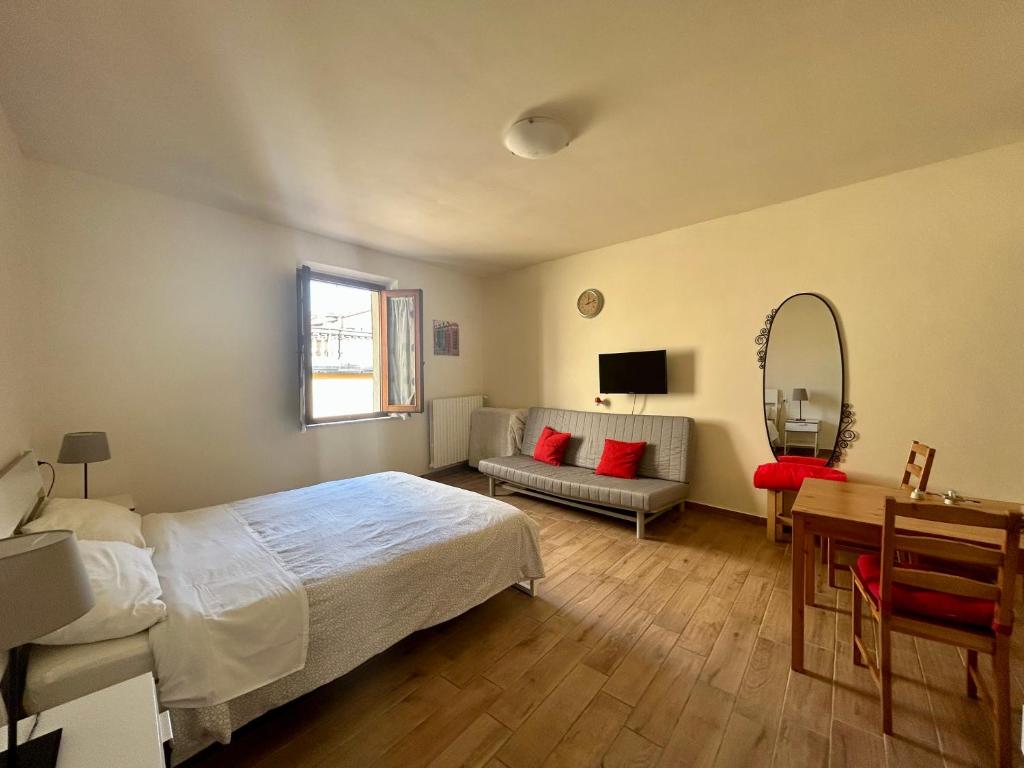 a bedroom with a bed and a desk and a mirror at Apartment Nel Centro Della Citta in Pistoia