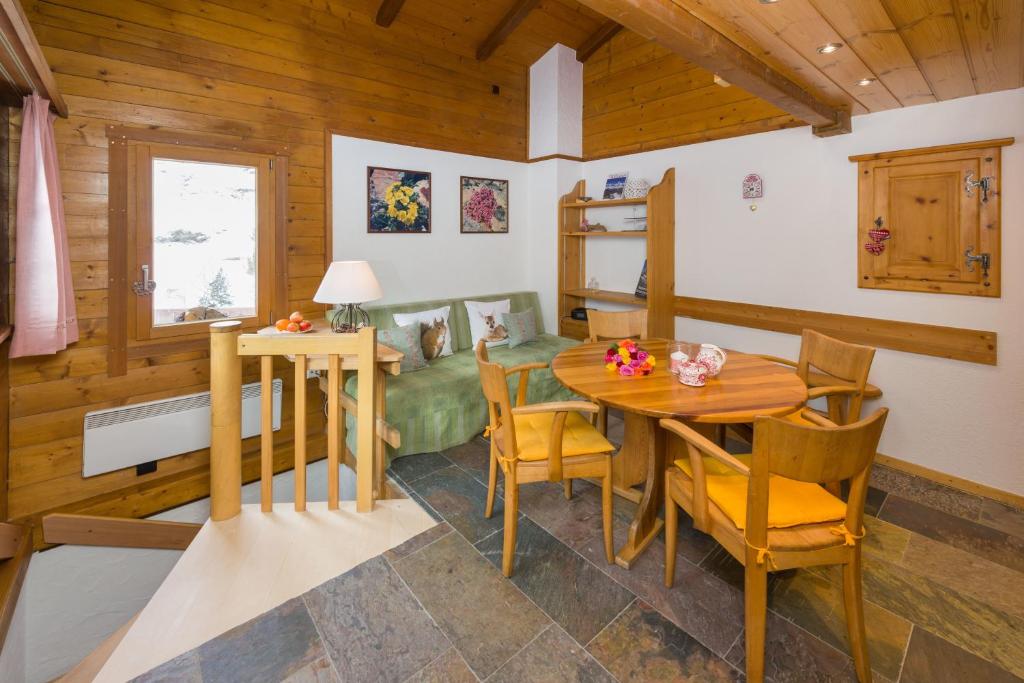 uma sala de jantar com mesa e cadeiras em Yukon em Zermatt