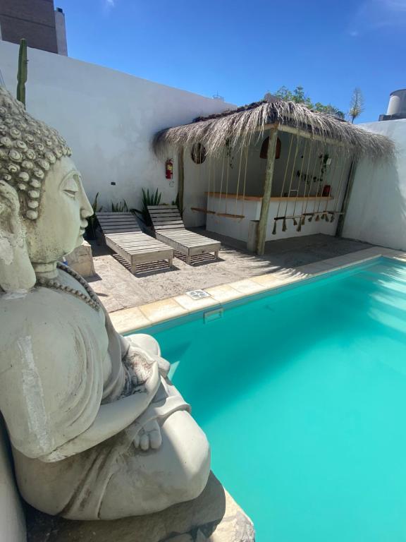 a statue sitting next to a swimming pool at Bardot Hostel in Paraná