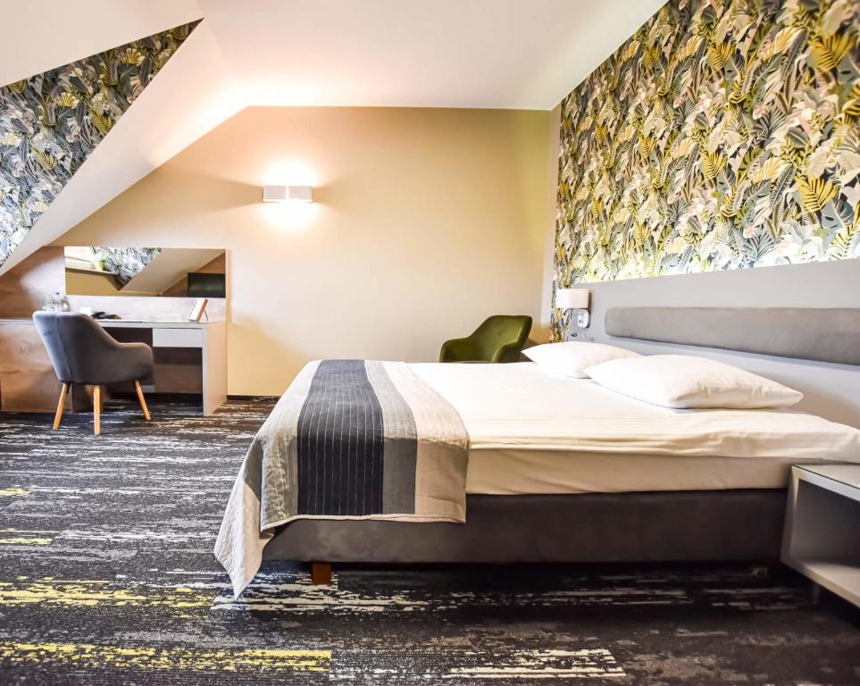 una habitación de hotel con una cama y un escritorio en Leśny Dwór, en Radom
