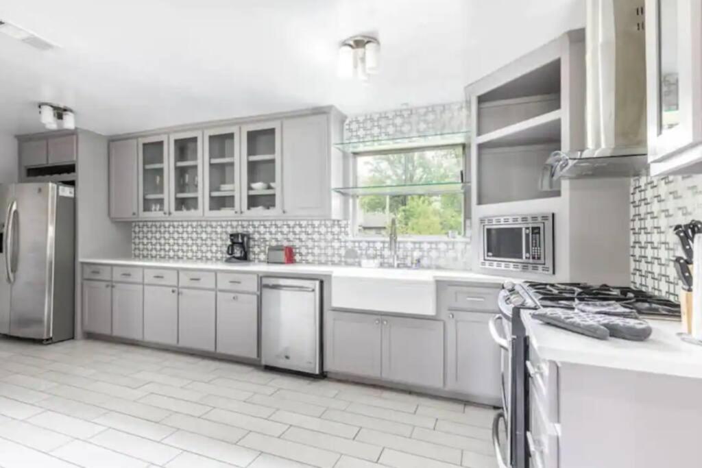 a large kitchen with white cabinets and appliances at Convenient Home Near Airport in Fort Worth