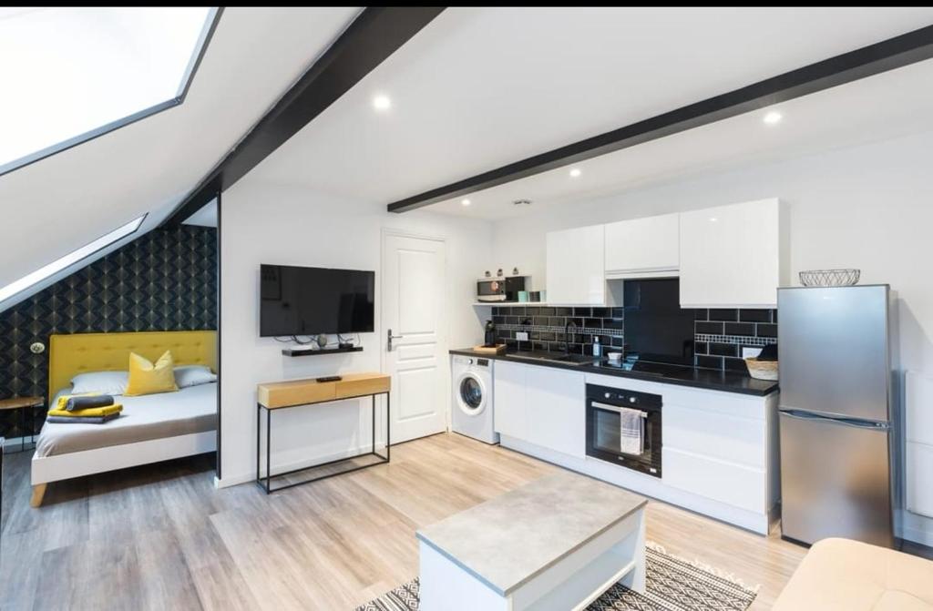 uma cozinha e sala de estar num loft em Bienvenue à Reims type studio charmant et lumineux 2eme étage em Reims