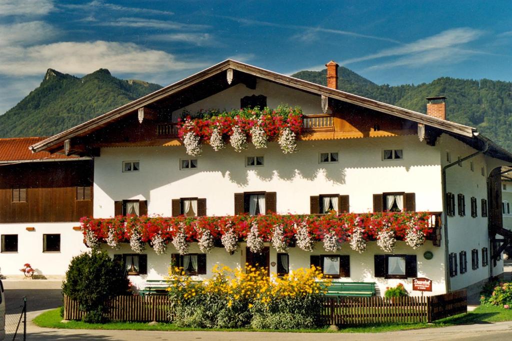 um edifício com flores ao lado em Bauernhof Daurerhof em Aschau im Chiemgau