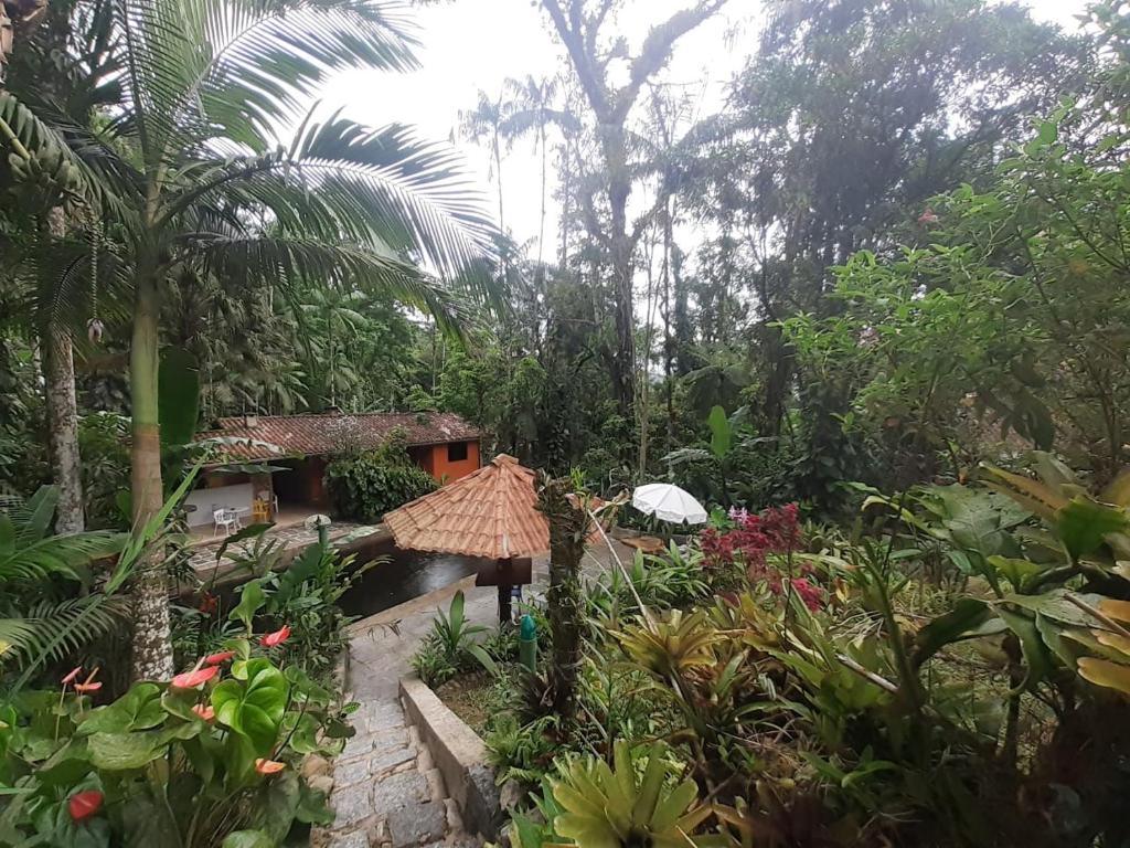 einen Garten mit einem Haus und einigen Pflanzen und Bäumen in der Unterkunft Toca da Onça in Penedo