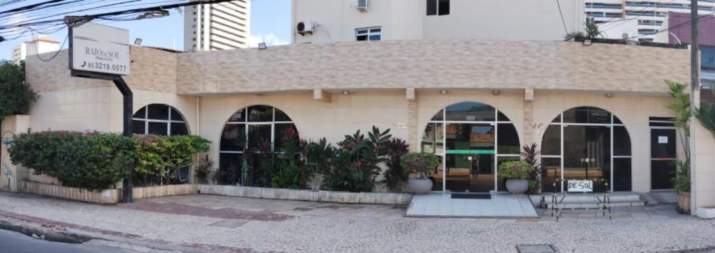 een gebouw met een tafel en stoelen ervoor bij Raio de Sol Praia Hotel in Fortaleza