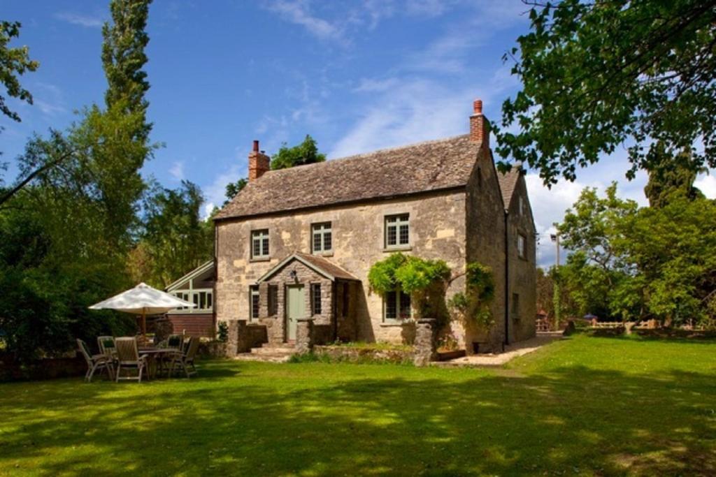 an old stone house with a green lawn at Hill Farm in Oxford