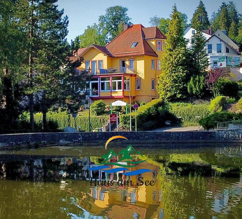 a house with a duck sitting in the water at Haus am See in Bad Sachsa