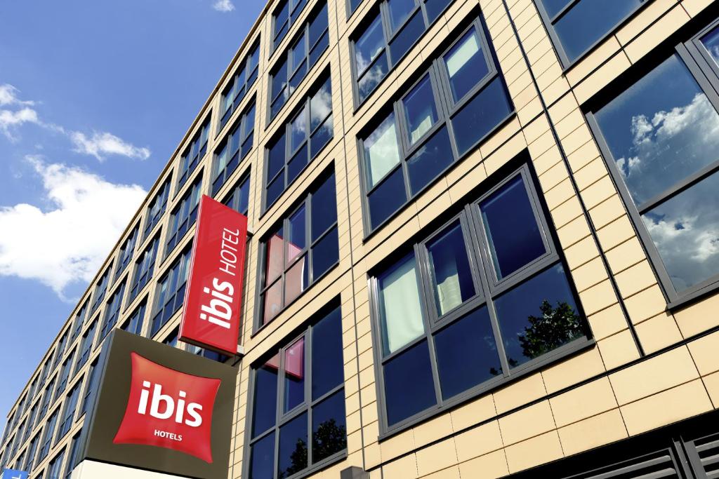 a tall building with signs in front of it at ibis München Parkstadt Schwabing in Munich