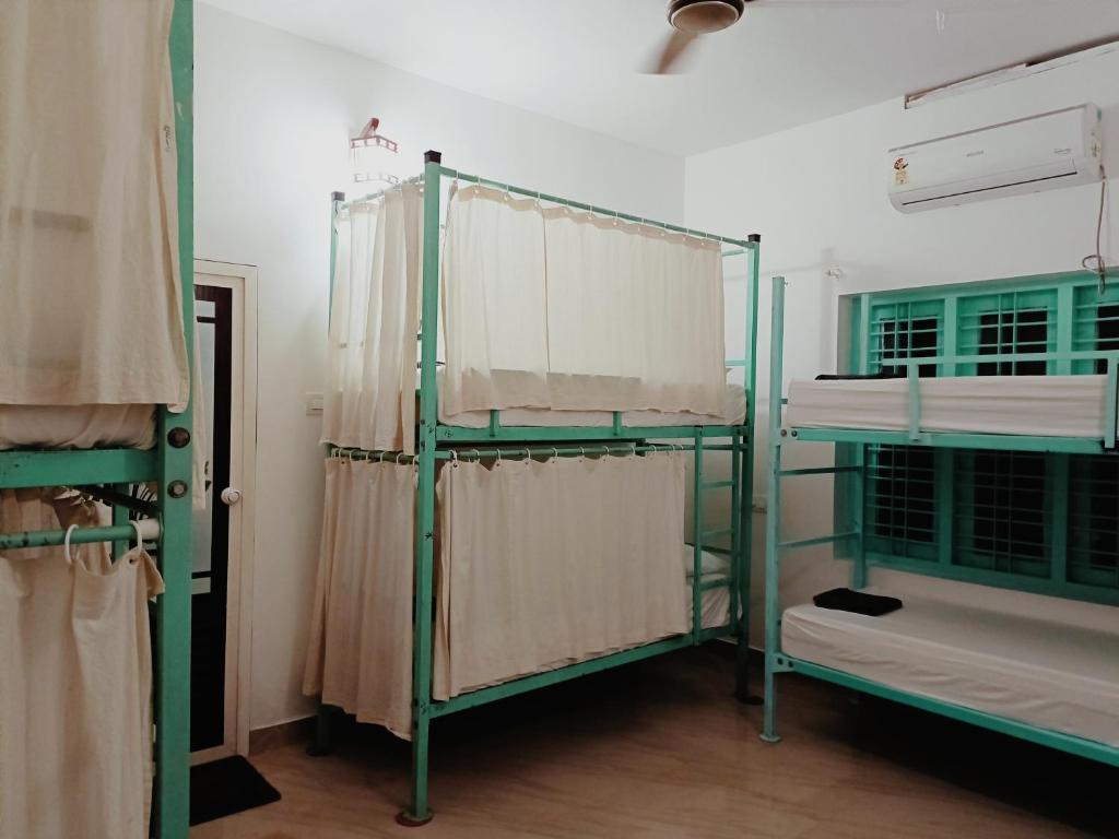 a room with three bunk beds and a window at Molly's Hostel in Varkala