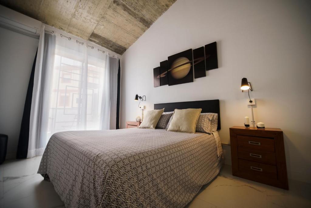 a bedroom with a bed and a large window at Casa suig in Baena