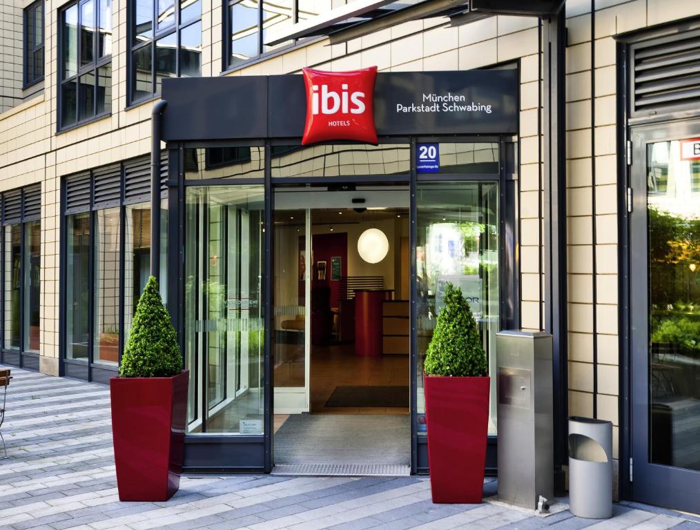 a store front with two potted trees in front of it at ibis München Parkstadt Schwabing in Munich