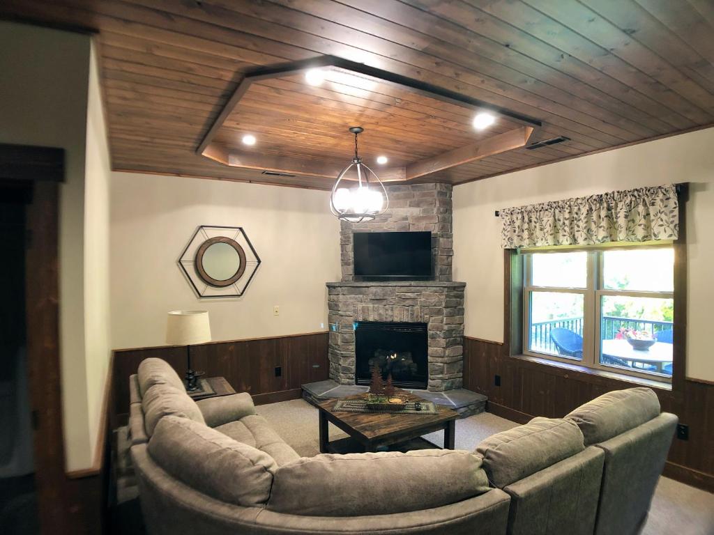 a living room with a couch and a fireplace at Sojourner's Lodge & Log Cabin Suites in Dundee