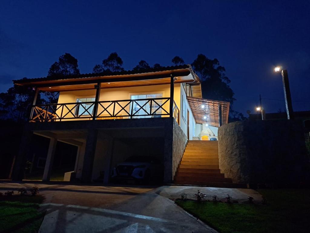a house with a staircase leading up to it at night at A Casa do Júnior em Visconde de Mauá in Visconde De Maua