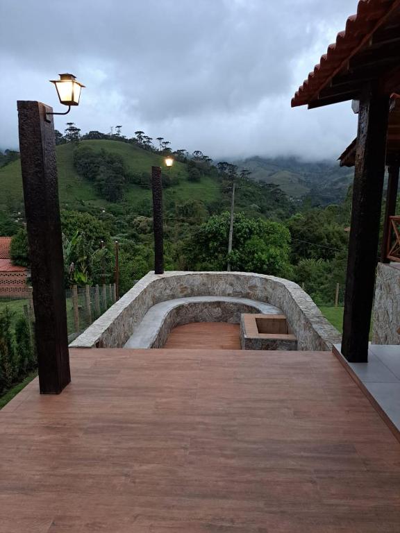 a wooden boardwalk with a bench on top of a mountain at A Casa do Júnior em Visconde de Mauá in Visconde De Maua
