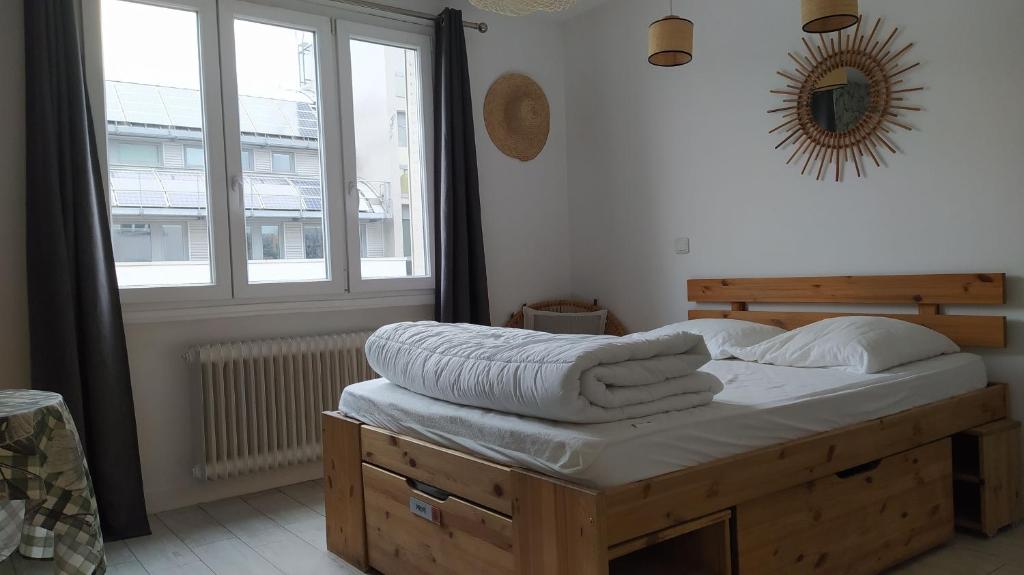 - une chambre avec un lit doté de draps blancs et une fenêtre dans l'établissement Le "Wood", à Annecy