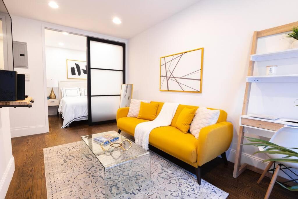 sala de estar con sofá amarillo y mesa en 69-3C Stylish Lower East East 1br Apt BRAND NEW, en Nueva York