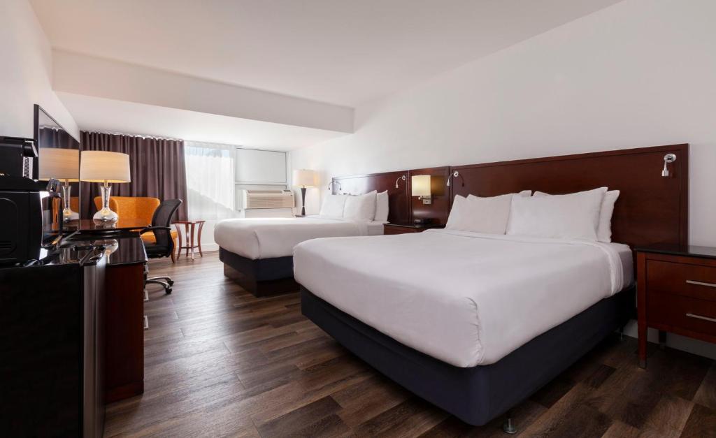 een hotelkamer met 2 bedden en een televisie bij Strata Hotel in Kingston