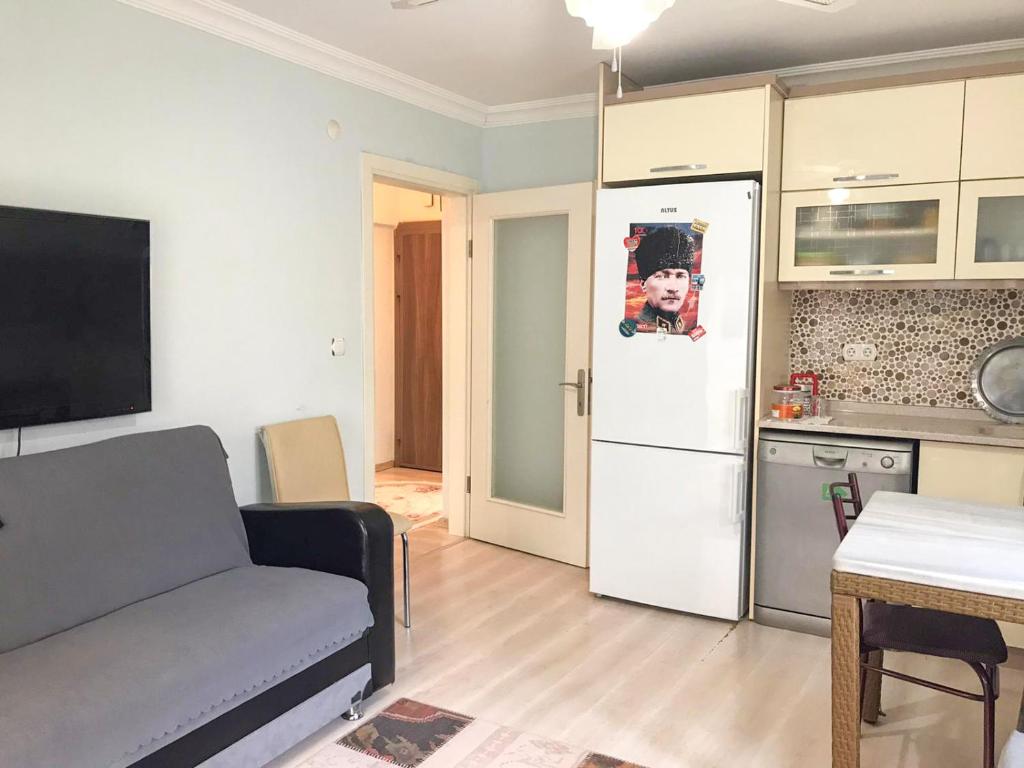 ein Wohnzimmer mit einem Sofa und einer Küche in der Unterkunft Altınkum Sahil'de bahçeli nezih yazlık in Edremit