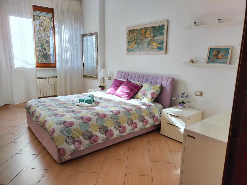 a small bedroom with a bed with pink pillows at Sunnyside Accademia in Livorno