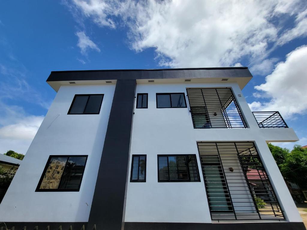 een wit gebouw met zwarte ramen en een blauwe lucht bij Modern - Wan Pipel with Terrace in Paramaribo