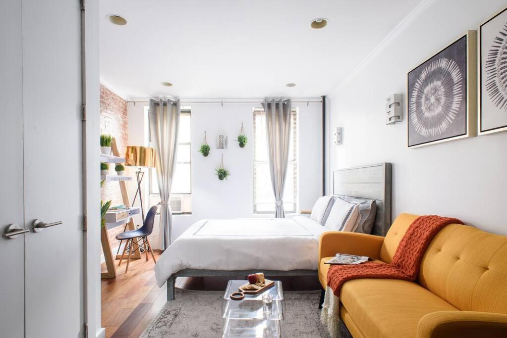 1 dormitorio con cama y sofá amarillo en 24-9 New Prime Gramercy Subway W D in unit en Nueva York