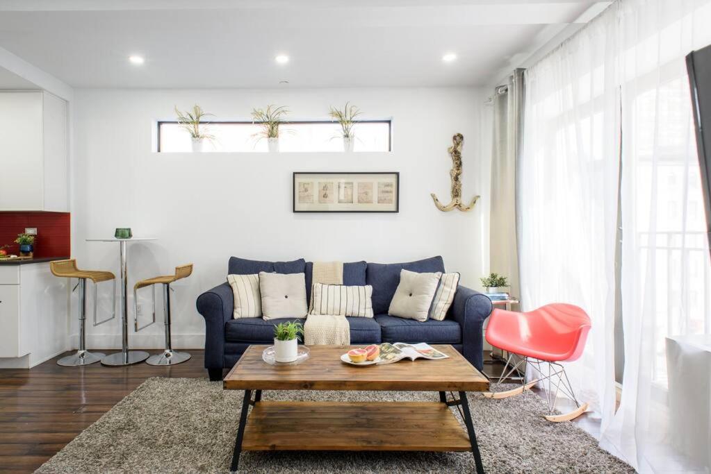 a living room with a blue couch and a table at 809-5A Gorgeous New 1BR Heart of Midtown in New York