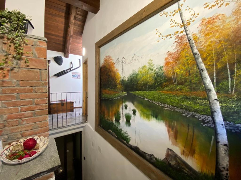 a large painting of a river on a wall at Locanda Tarello1880 in Roppolo