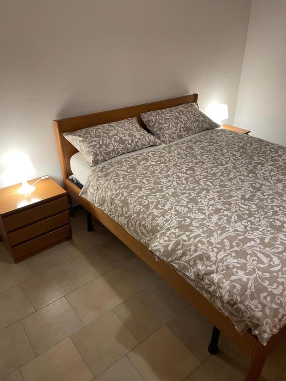 uma cama num quarto com uma mesa de cabeceira e uma cama sidx sidx sidx em Ale E-Commerce Holiday Home em Buccinasco