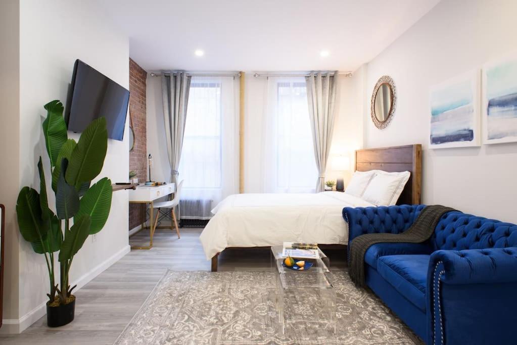 240-9 Luxury Prime Location STUDIO W&D في نيويورك: غرفة نوم بسرير واريكة زرقاء
