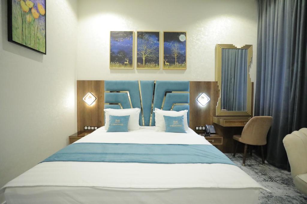 Habitación de hotel con cama, escritorio y cama sidx sidx en MaxWell Hotel & SPA, en Tashkent