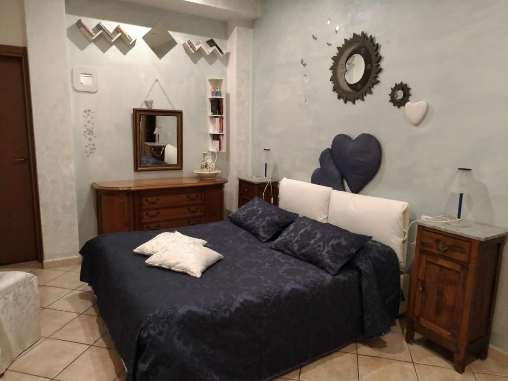 Schlafzimmer mit einem Bett mit blauer Bettwäsche und einem Spiegel in der Unterkunft Rosaspina in Grosseto