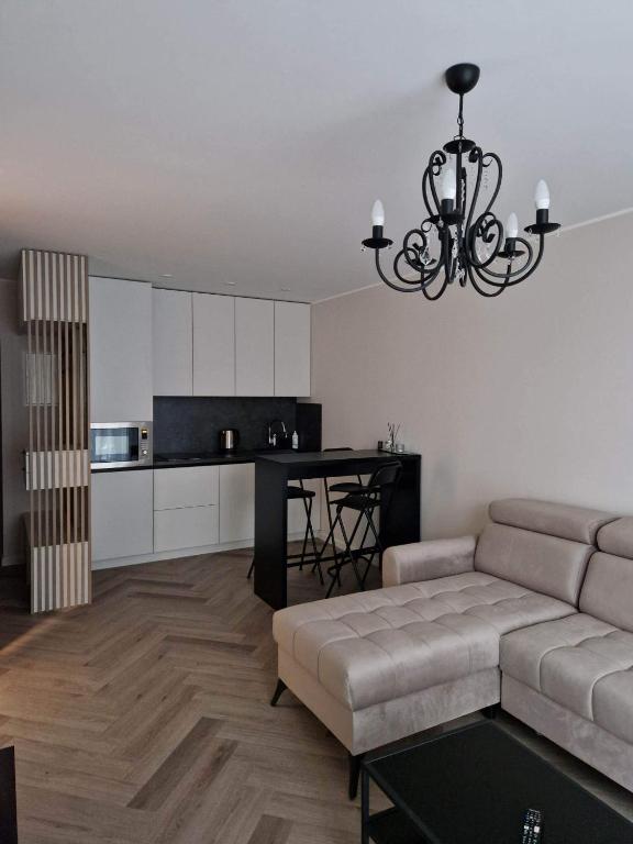 sala de estar con sofá y mesa en Parko nauji apartamentai, en Panevėžys