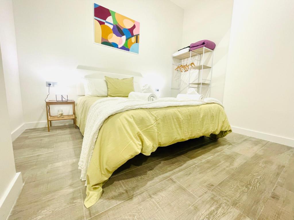 ein Schlafzimmer mit einem Bett mit einer gelben Decke in der Unterkunft Cómodo, moderno y bien situado P3 in Málaga