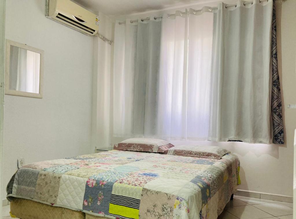 1 dormitorio con cama y ventana en APARTAMENTO QUADRA MAR BALNEÁRIO CANBORIU SC, en Balneário Camboriú