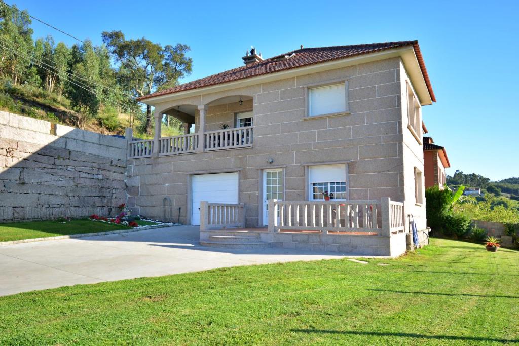 a large brick house with a balcony on a yard at Apartamento da Pedra e da Auga in Meis