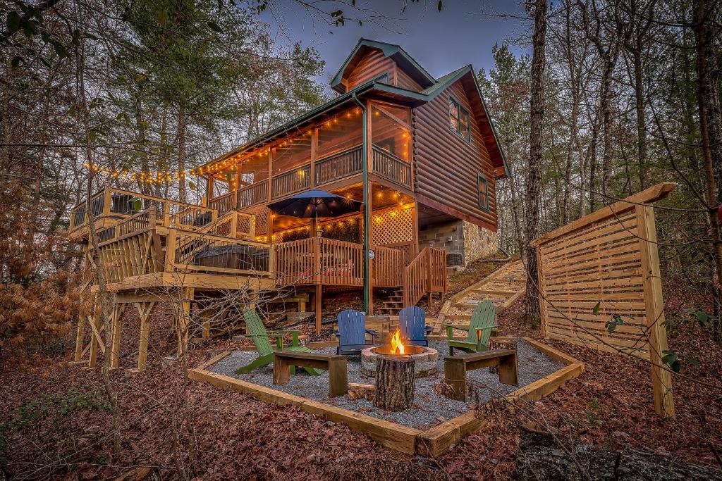 una gran casa de madera en el bosque con una hoguera en New! Treetop Cabin - Hot tub, Firepit & Fast WiFi, en Blue Ridge